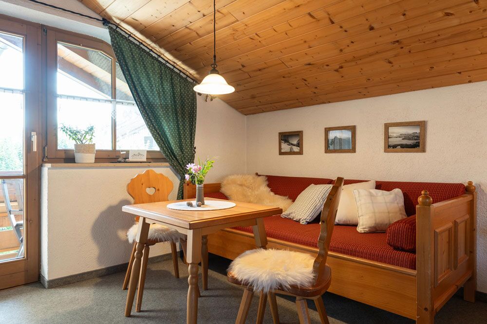 Gemütliche Sitzecke – hier schmeckt das Frühstück mit Bergblick Helle Essecke mit Holztisch und Fensterblick in der Ferienwohnung Martin im Allgäu