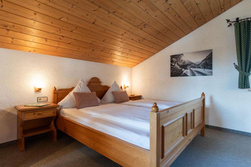 Erholsamer Schlaf mit Bergluft und Wohlfühlkomfort Schlafzimmer der Ferienwohnung Martin mit Doppelbett und warmem Holzdesign